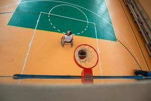 tow view photo of a war veteran playing basketball in a modern sports arena. The concept of sport for people with disabilities