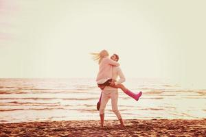 Loving young couple on a beach at autumn sunny day photo