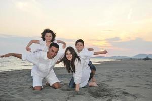 familia joven feliz divertirse en la playa foto