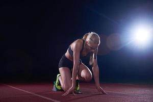 woman  sprinter leaving starting blocks photo