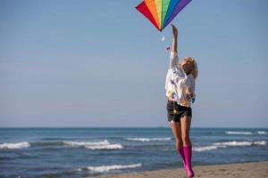 Young Woman with kite at beach on autumn day photo