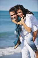 feliz pareja joven divertirse en la hermosa playa foto