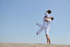 happy young couple have fun on beach photo