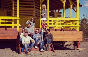 grupo de amigos divirtiéndose el día de otoño en la playa foto