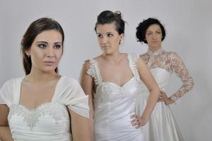 portrait of a three beautiful woman in wedding dress photo