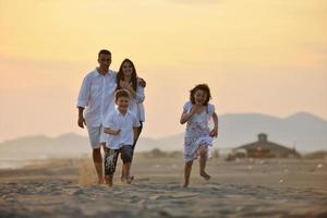 familia joven feliz divertirse en la playa foto