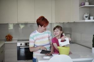 madre e hija jugando y preparando masa en la cocina. foto