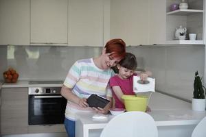 madre e hija jugando y preparando masa en la cocina. foto