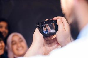 A father with a camera photographs his children as they pose with a smile on their face photo