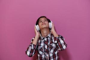 Arab Teenage Boy Wearing Headphones And Listening To Music photo