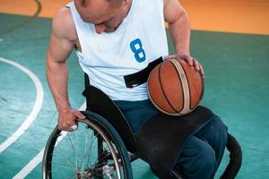 Close up photo of wheelchairs and handicapped war veterans playing basketball on the court