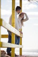 young couple drinking beer together at the beach photo