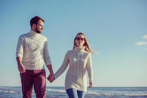 Loving young couple on a beach at autumn sunny day photo