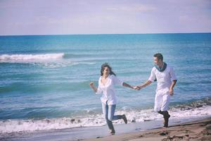 feliz pareja joven divertirse en la hermosa playa foto