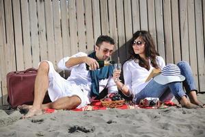 pareja joven disfrutando de un picnic en la playa foto