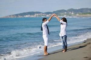 feliz pareja joven divertirse en la hermosa playa foto