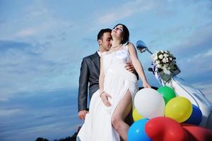 just married couple on the beach ride white scooter photo