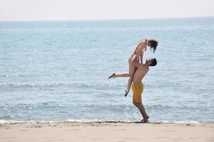 happy young couple have fun on beach photo