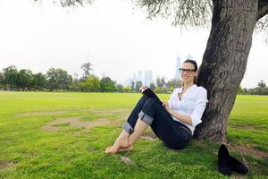 Young woman reading a book in the park photo