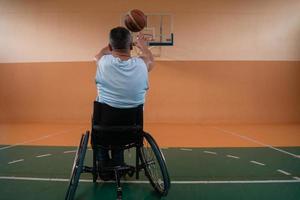 Close up photo of wheelchairs and handicapped war veterans playing basketball on the court