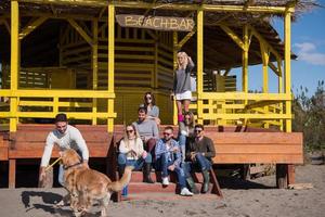 grupo de amigos divirtiéndose el día de otoño en la playa foto