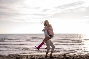 amorosa pareja joven en una playa en el día soleado de otoño foto