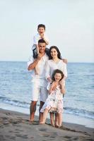 familia joven feliz divertirse en la playa foto