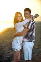 happy young couple have fun on beach photo