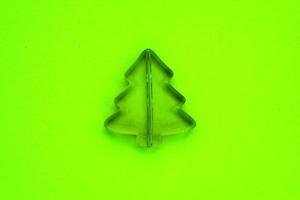 Christmas composition from little plastic pine tree on neon green background. Holidays, winter and celebration concept. Idea for greeting card, poster sale, banner, web. Flat lay, top view. Close-up photo