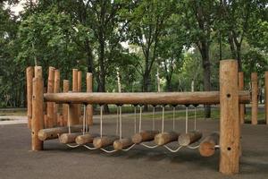 Rope bridge in outdoor modern children wooden playground in a public park of city. Eco-friendly lifestyle rest and childhood concept of safety environmentally infrastructure for kids. Funny adventure photo