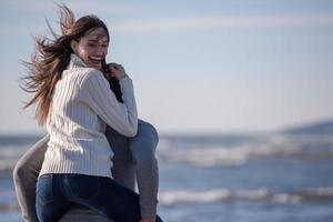 pareja divirtiéndose en la playa durante el otoño foto