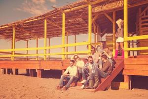 grupo de amigos divirtiéndose el día de otoño en la playa foto