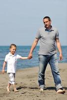 feliz padre e hijo se divierten y disfrutan del tiempo en la playa foto