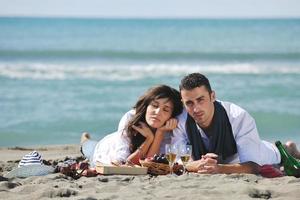 young couple enjoying  picnic on the beach photo