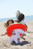 grupo de jóvenes felices divertirse en la playa foto