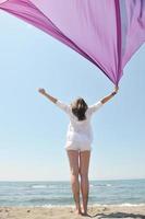 beautiful young woman on beach with scarf photo