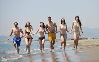 grupo de jóvenes felices divertirse en la playa foto