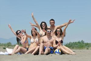 grupo de jóvenes felices divirtiéndose en la playa foto