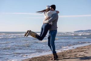 Loving young couple on a beach at autumn sunny day photo