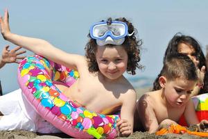 grupo infantil divertirse y jugar con juguetes de playa foto