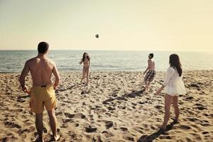 grupo de jóvenes divertirse y jugar voleibol de playa foto