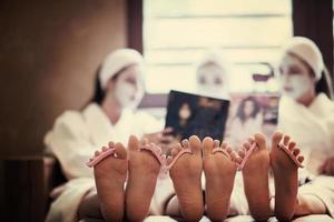 bachelorette party in spa, girls with face mask reading magazine photo