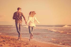 Loving young couple on a beach at autumn sunny day photo