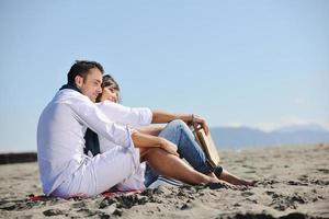 pareja joven disfrutando de un picnic en la playa foto