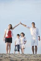 family on beach showing home sign photo