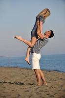 happy young couple have fun on beach photo