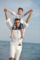 happy father and son have fun and enjoy time on beach photo