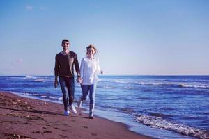 Loving young couple on a beach at autumn sunny day photo