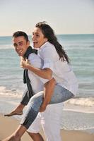 feliz pareja joven divertirse en la hermosa playa foto