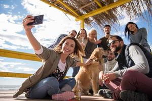 grupo de amigos divirtiéndose el día de otoño en la playa foto